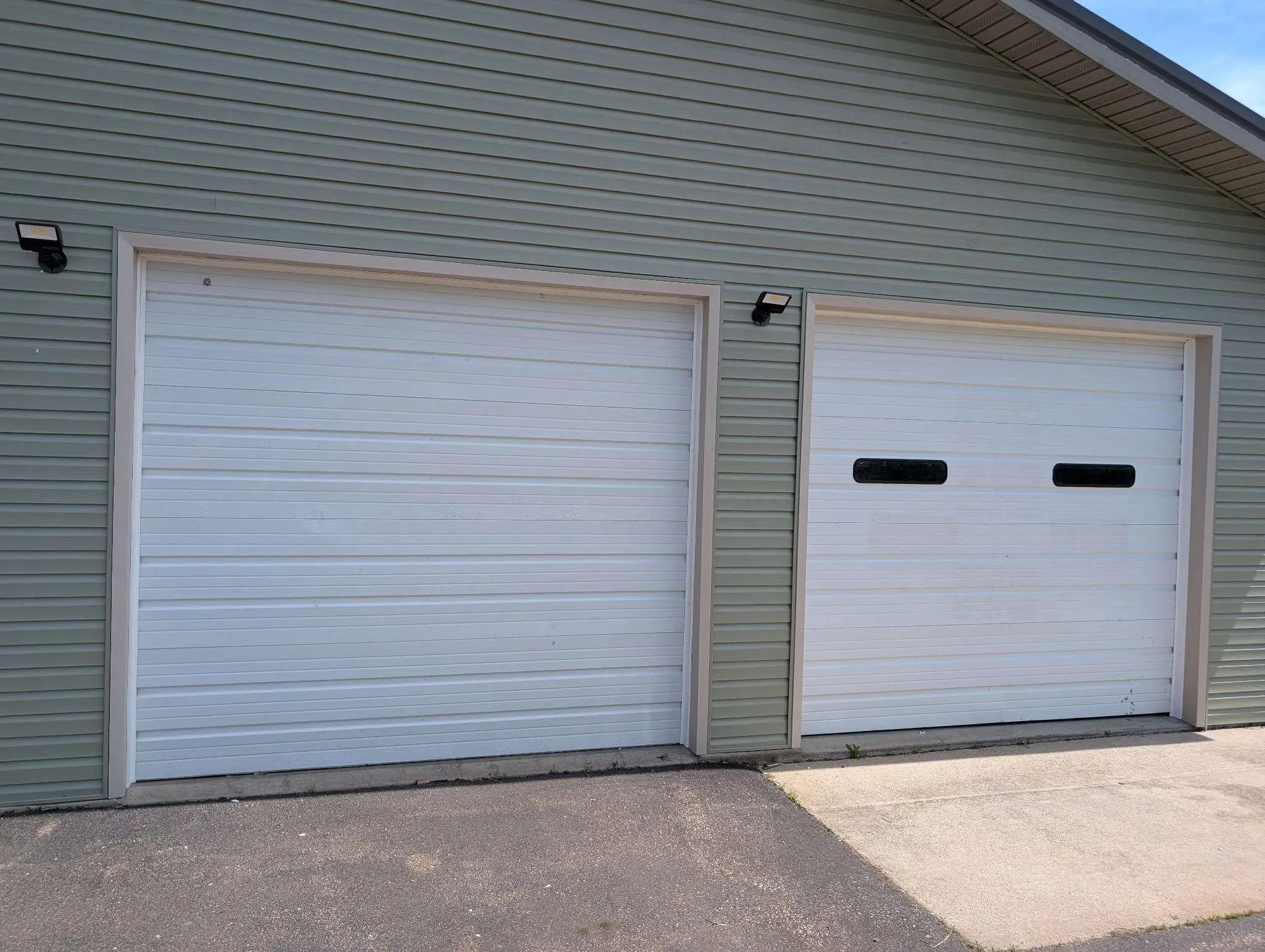 Double white roll-up garage doors with sage green lap siding, Carter Quality Construction