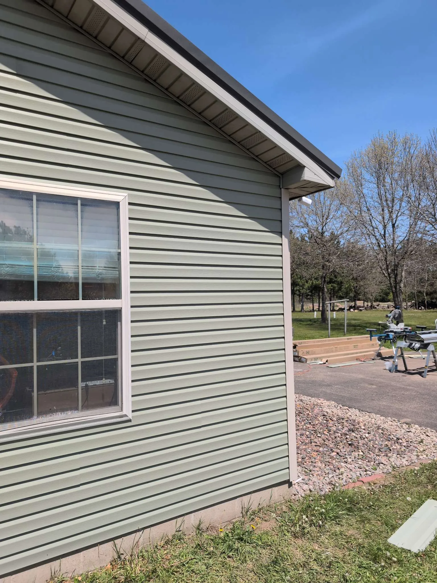 House exterior with sage green lap siding and double-hung window, Chippewa Valley WI
